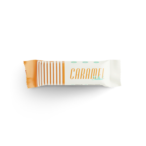 Salted caramel protein bar in white and gold wrapper on a black background
